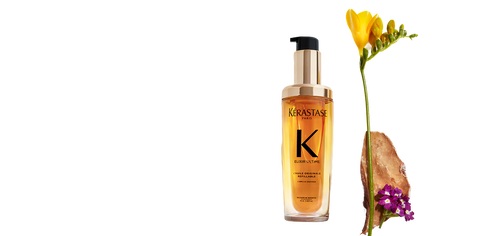 Kerastase Elixir Ultime Hair Oil bottle next to flowers