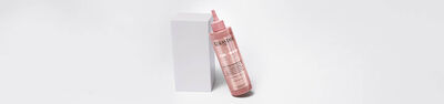 Bottle of Chroma Absolu Chroma Gloss Treatment leaning on a white block