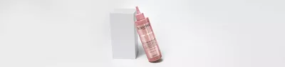 Bottle of Chroma Absolu Chroma Gloss Treatment leaning on a white block