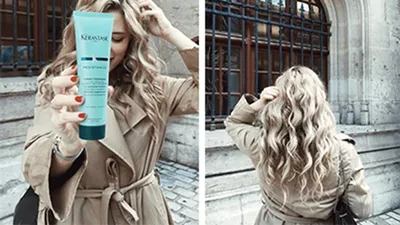 Model with smooth long curly blonde hair holding a tube of Resistance Ciment Thermique Heat Protector