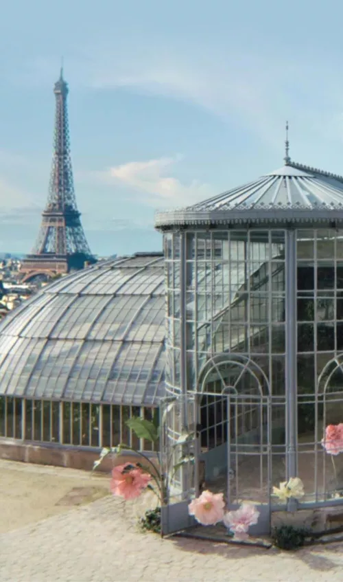 View of a greenhouse with roses around with the Eiffel Tower in the background
