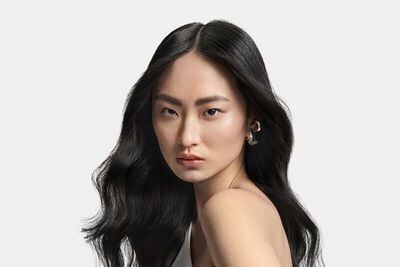 Model with sleek shiny dark wavy hair
