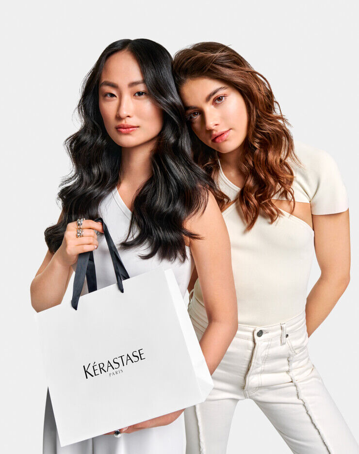 Two models with Kerastase branded gift bag