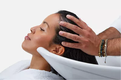Une femme se fait laver les cheveux en salon de coiffure