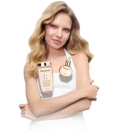 Model with sleek blonde hair and 2 Kerastase Gloss Absolu products