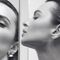 Monochrome portrait of woman with sleek hair reflected in mirrors