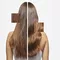 Model shows her shiny healthy dark hair after using Elixir Ultime hair oil.