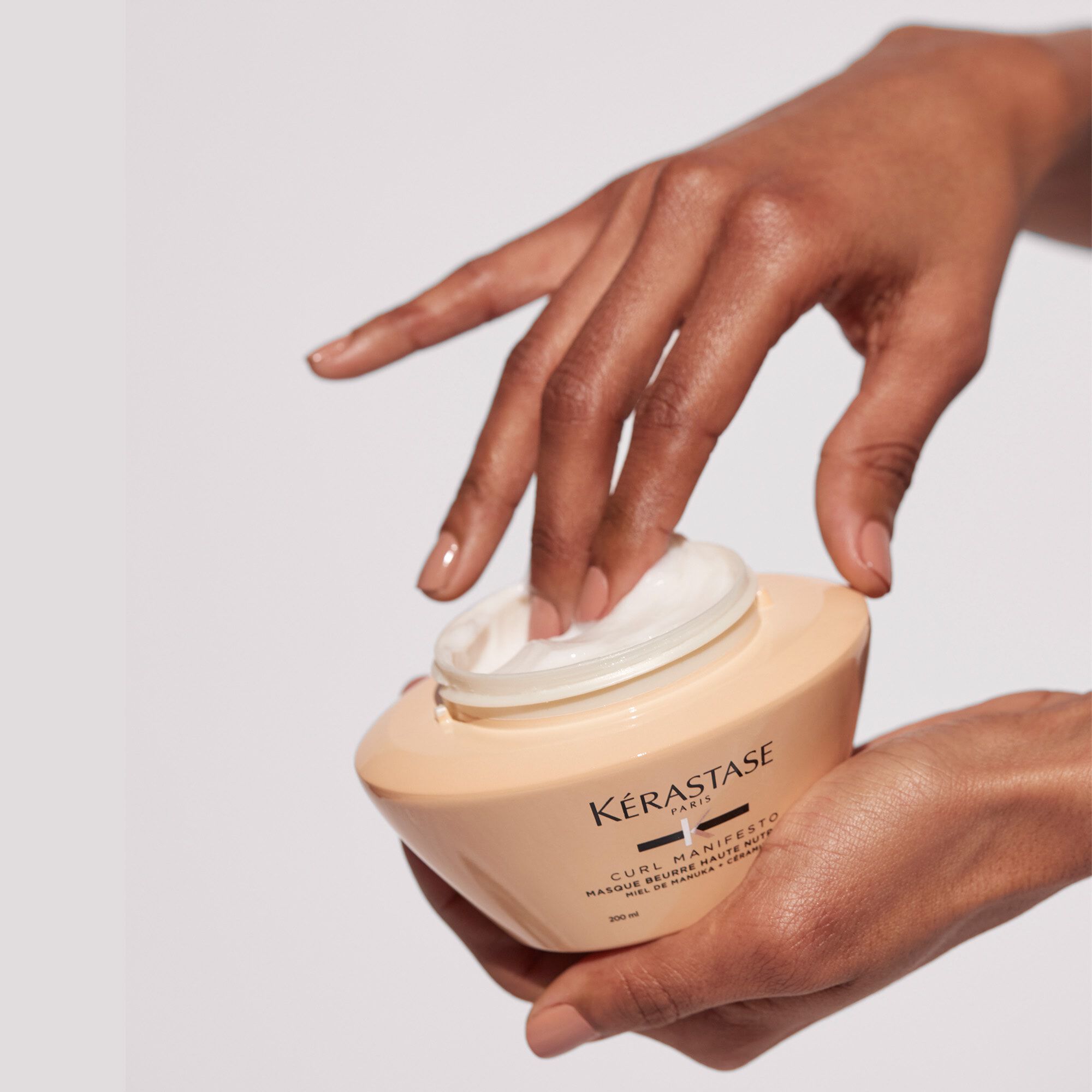 Kerastase Masque Beurre Haute Nutrition Curl Manifesto Revitalisant pour cheveux boucles produit en main