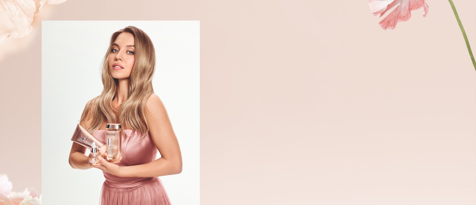 Model in rose-pink dress holding three Kérastase Gloss Absolu hair care products