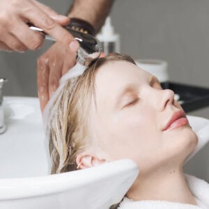 A woman has her hair washed at a hair salon