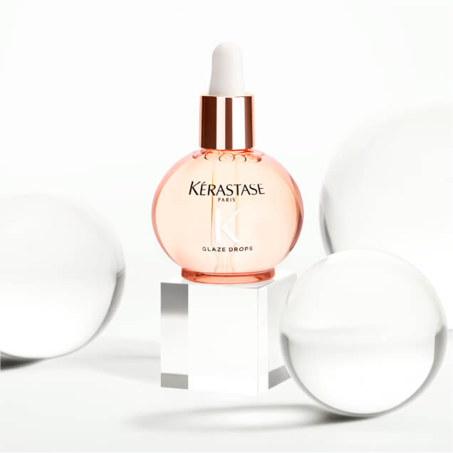 Gloss Absolu Glaze Drops bottle surrounded by glass decor